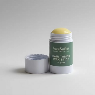 Hair tamer wax stick with green label on a gray background