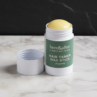 Hair tamer wax stick with green label on a marble surface